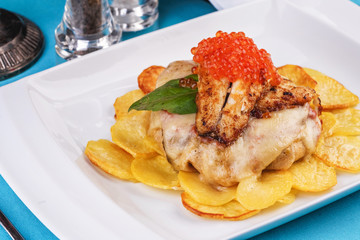 Seafood, Mediterranean cuisine, European dish. Sea salmon Fish steak with greens, country-style fried potatoes, cheese and cream sauce. Caucasian national cuisine