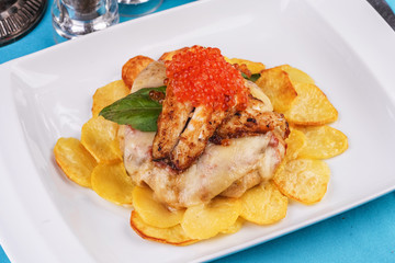 Seafood, Mediterranean cuisine, European dish. Sea salmon Fish steak with greens, country-style fried potatoes, cheese and cream sauce. Caucasian national cuisine