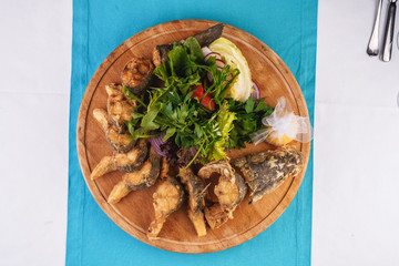 Seafood, Mediterranean cuisine. Grilled Seafood Steaks fish with herbs, carrots, tomatoes, cilantro, lemon and onions. Caucasian national cuisine