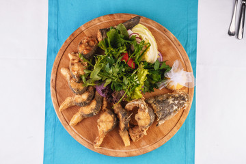 Seafood, Mediterranean cuisine. Grilled Seafood Steaks fish with herbs, carrots, tomatoes, cilantro, lemon and onions. Caucasian national cuisine