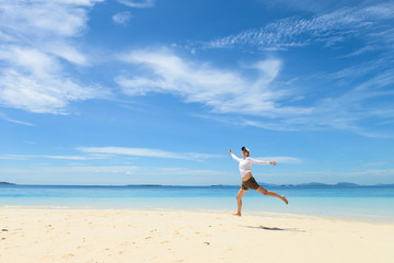 Fototapeta na wymiar single young girl on tropical white sand beach running toward horizon. Semporna, Sabah, Malaysia