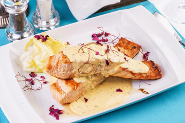 Seafood, Mediterranean cuisine. Sea Salmon Steak fish with greens, cabbage and cheese with cream sauce. Caucasian national cuisine