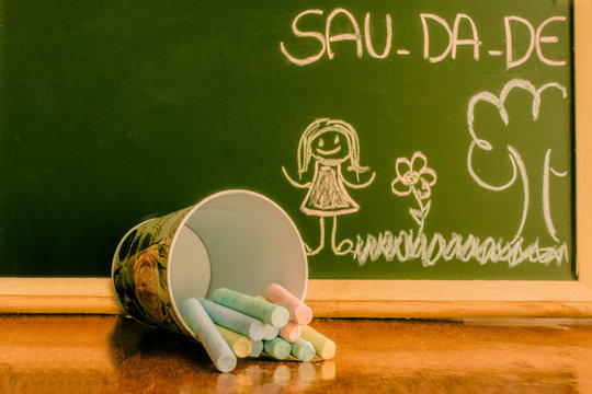 Quadro verde com desenho infantil e escrita saudade dividida em s&iacute;labas