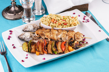 Mediterranean dish, Georgian recipe. Baked chicken skewers with lemon, vegetables, pepper, zucchini, eggplants and grilled tomatoes with spices, and steamed rice