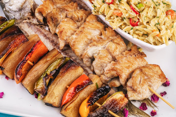 Mediterranean dish, Georgian recipe. Baked chicken skewers with lemon, vegetables, pepper, zucchini, eggplants and grilled tomatoes with spices, and steamed rice