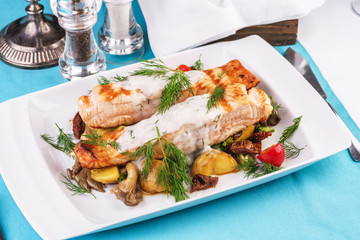 Seafood, Mediterranean cuisine. Grilled salmon fish steak with grilled vegetables and oyster mushrooms. Caucasian kitchen