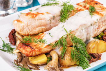 Seafood, Mediterranean cuisine. Grilled salmon fish steak with grilled vegetables and oyster mushrooms. Caucasian kitchen
