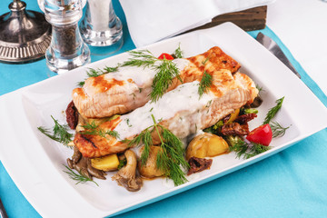 Seafood, Mediterranean cuisine. Grilled salmon fish steak with grilled vegetables and oyster mushrooms. Caucasian kitchen