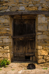 Fototapeta na wymiar A door in a derelict stone house in the small historic hill village of Obenetto in Friuli-Venezia Giulia, north east Italy
