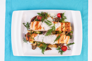 Seafood, Mediterranean cuisine. Grilled salmon fish steak with grilled vegetables and oyster mushrooms. Caucasian kitchen