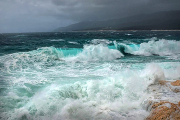 Stormy sea view  near coastline at evening time. Waves, splashed