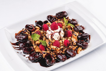 Berry-chocolate cake with ice cream, chocolate sauce and dates