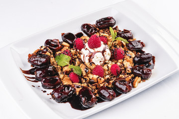 Berry-chocolate cake with ice cream, chocolate sauce and dates