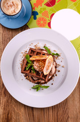Fototapeta na wymiar Plate of belgian chocolate waffles with slice orange, ice cream, caramel sauce and fresh mint on elegant white plate on wooden background. Close up. Top view dessert, copy space text