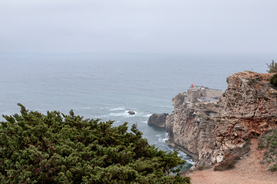 Nazare, Portugal - July 19, 2019 : The Nazare lighthouse, or Farol do Nazare, photographed from above on a misty day