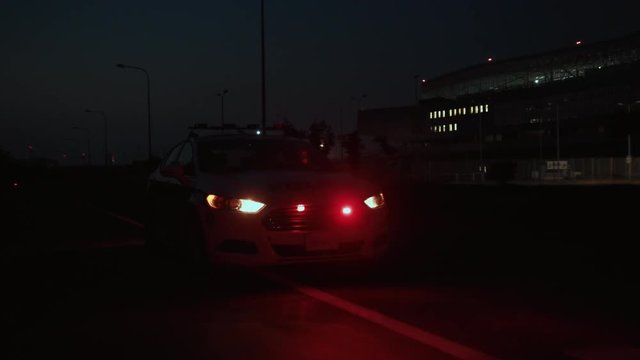 high speed police car driving along the highway in city suburbs in dark night. emergency call. policemen on duty.