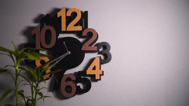 Timelapse of original wall clock with different color numbers and silver clock hands.