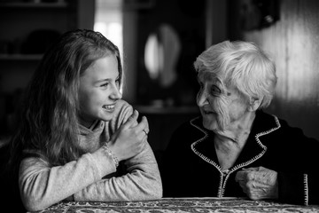 A little cute girl with a grandmother in the house black and white photo.
