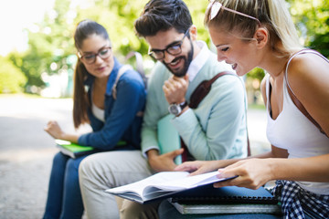 Happy group of friends studying and talking together at university