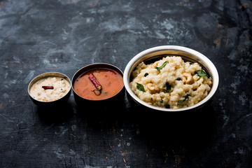 Ven pongal recipe is a popular South Indian food prepared with rice & moong dal and served with sambar and coconut chutney, selective focus