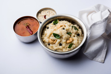 Ven pongal recipe is a popular South Indian food prepared with rice & moong dal and served with sambar and coconut chutney, selective focus