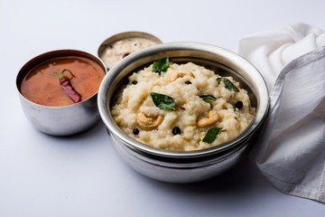 Ven pongal recipe is a popular South Indian food prepared with rice & moong dal and served with sambar and coconut chutney, selective focus