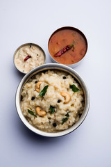 Ven pongal recipe is a popular South Indian food prepared with rice & moong dal and served with sambar and coconut chutney, selective focus