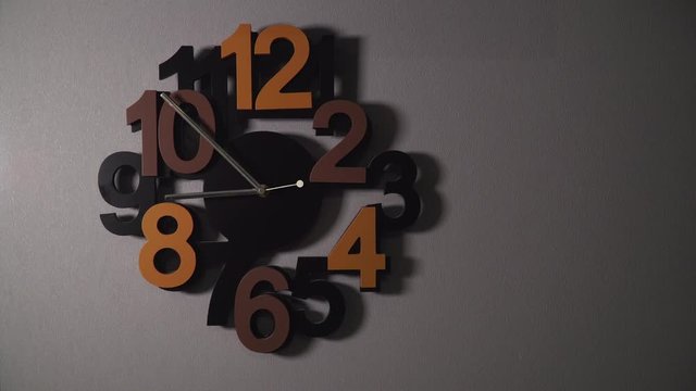 Timelapse of original wall clock with different color numbers and silver clock hands.