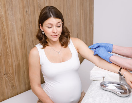 Doctor Injecting A Vaccine In Arm Of Pregnant Woman - Pregnancy Vaccination Concept