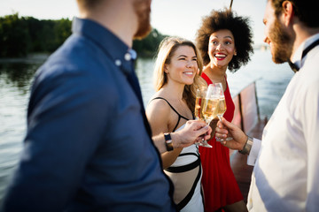 Group of friends drinking, chatting and having a fun at outdoor party