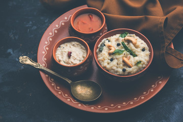 Ven pongal recipe is a popular South Indian food prepared with rice & moong dal and served with sambar and coconut chutney, selective focus