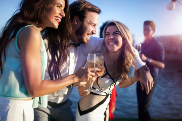 Group of happy friends partying and toasting drinks