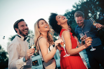 Group of happy friends drinking champagne and celebrating New Year