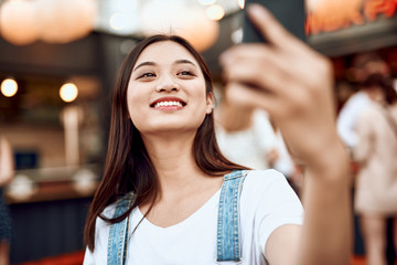 Happy asian lady making selfie on city view