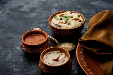 Ven pongal recipe is a popular South Indian food prepared with rice & moong dal and served with sambar and coconut chutney, selective focus