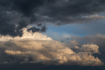 Fototapeta na wymiar Dramatic big white fluffy storm cumulus clouds in blue sky 