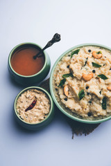 Ven pongal recipe is a popular South Indian food prepared with rice & moong dal and served with sambar and coconut chutney, selective focus