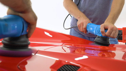 In the car center (in the garage), professionals polish a new sports car. Luxury car polishing. Concept of: Racing, Sport car, New, Slow motion, Nascar, Red, Chrome plated.