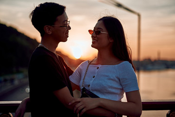 Happy stylish asian couple enjoying date on sunset