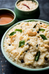 Ven pongal recipe is a popular South Indian food prepared with rice & moong dal and served with sambar and coconut chutney, selective focus