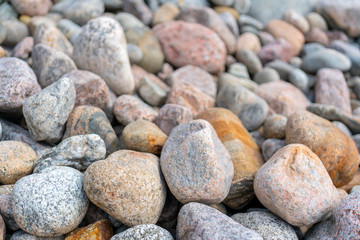 Pebbles on the shore. Round stones on the coast.