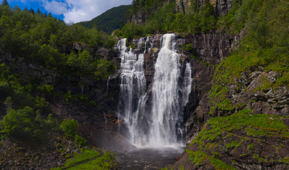 Fototapeta na wymiar Frontal view of the Skjervsfossen in summer, seen from the base. Norway.