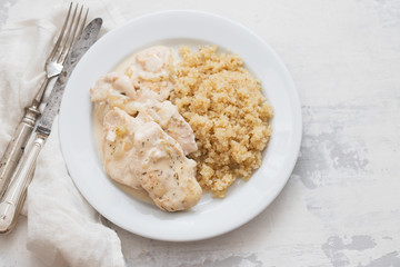 dish of meat with sauce and boiled quinoa on white wooden background