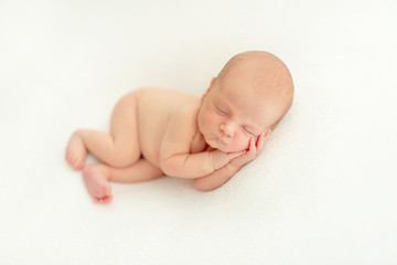 Dreamy newborn baby sleeping on bed