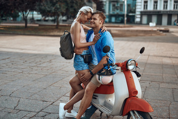 Beautiful romantic couple smiling when hugging on the motorbike