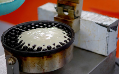 Closeup view of batter being poured in to electrical equipment to make baffle    