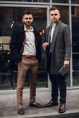 Two handsome men working. Friends talking. Man in a suit and coat