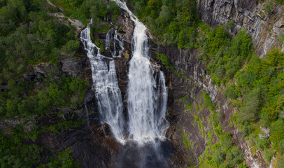 Fototapeta na wymiar Frontal view of the Skjervsfossen waterfall in summer, seen from the base. Norway.