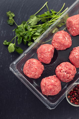raw meatballs with pepper and salt in plastic box