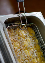 Closeup of deep frying of sliced or cut potato chips 